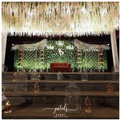 For receptions, I love designing spaces that feel both glamorous and inviting. This stage features a lush green fern wall dotted with flowers, a cascading floral ceiling, and a comfortable velvet sofa, creating a luxurious yet relaxed setting for the couple to celebrate.