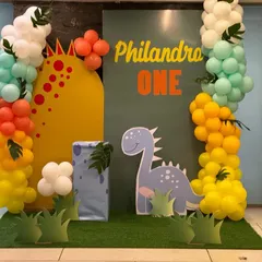 A cute and colorful dinosaur theme for a first birthday. This backdrop features a friendly dinosaur cutout, a personalized name panel, and bright balloon columns to create a fun, prehistoric world.