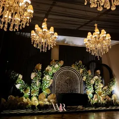 The stage for a jazz-themed cocktail night. I used a black sequined backdrop with a central arch, framed by an explosion of white florals and golden palm fronds, creating a look of pure art deco glamour.