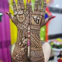 A stunning full-coverage bridal design on both hands. This style uses dense, intricate patterns and a bold initial monogram to create a very rich and traditional look.