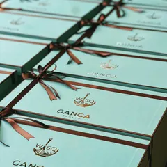 We make corporate gifting sweeter with our signature dessert boxes. This large order for Ganga Realty features our Tiffany blue boxes with co-branded logos, tied with elegant brown ribbons.