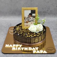 A timeless moment captured on a cake for a father's birthday. This design features an edible photo in a golden frame, elegantly placed on a rich chocolate cake.