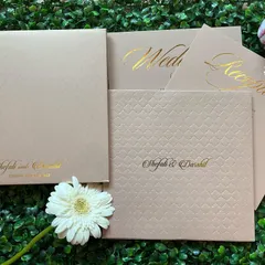 For a minimalist and modern look, this booklet-style invitation uses high-quality textured paper in a neutral beige tone. The couple's names are elegantly printed in gold foil, creating a simple yet luxurious feel.