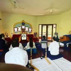 Devotees sit for a long meditation during a Christmas retreat. The use of Aum boards, as seen in the foreground, helps practitioners maintain correct posture for extended periods of deep practice.