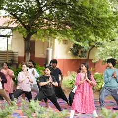 A group of participants in a warrior pose variation, building strength and focus together.