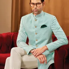 A moment of quiet confidence. This light aqua bandhgala jacket, crafted from a subtly patterned fabric, is paired with classic white trousers for a fresh and elegant look.