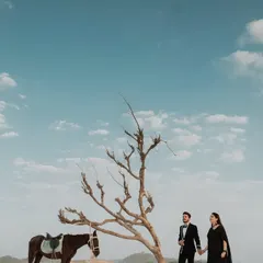 A wide-angle view of the couple and horse against the expansive sky, emphasizing the feeling of freedom and adventure in this unique location shoot.