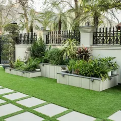 A well-curated garden tells a story. In this front yard, we used tiered planters to create depth and layered various plants and sculptures to reflect the client's vision, turning a simple lawn into a curated green space.