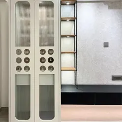 A modern and tranquil puja unit designed with fluted glass doors and light laminate. The small brass bells integrated into the door design add a traditional touch and a gentle sound.