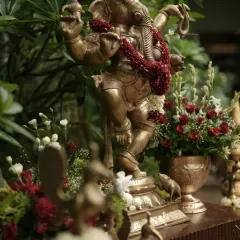 A dancing Ganesha idol, adorned with a red floral garland, placed prominently to bless the union. I always incorporate these sacred touches to honor our traditions.