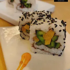 A close-up of our vegetarian sushi rolls. Filled with fresh, crisp vegetables and coated in black sesame seeds, these rolls offer a light and healthy option, demonstrating our versatility in handling global cuisines.