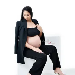 A modern and chic maternity portrait of an expectant mother in a black pantsuit. This confident and stylish look is a fantastic alternative to traditional gowns.
