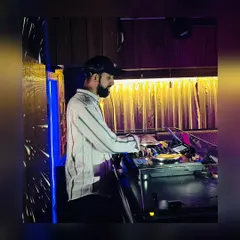 A side profile shot of me at the DJ booth. I am completely focused on the music and the crowd's reaction during my sets.