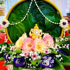 This is a close up of one of my auspicious platters, featuring a Ganesha idol. I use fresh betel leaves, vibrant roses, and jasmine garlands to create a beautiful centerpiece perfect for any pooja or traditional ceremony.