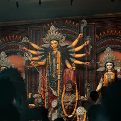 A powerful shot of the Durga idol at a pandal in Delhi. The low angle and the crowd in the foreground give a sense of scale and the overwhelming divine presence during Durga Puja.