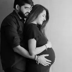 A classic black and white couple's portrait. The simplicity of monochrome emphasizes the emotional connection and the quiet anticipation of parenthood.
