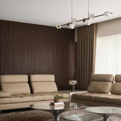 A detail of the living room, showing the contrast between the dark fluted wood accent wall and the soft beige leather sofas. A modern glass bubble chandelier adds a touch of sculptural elegance.