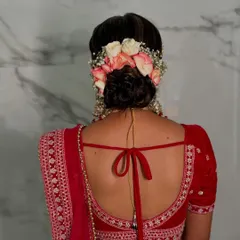 A stunning bridal bun decorated with a crown of fresh pink and white roses and baby's breath. This is the perfect romantic hairstyle for a bride.