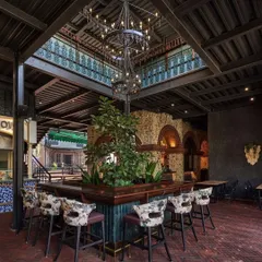 For the interior of Street 1522, I integrated this large, mature tree as the centerpiece of the main bar. This brings the outdoors in, creating a unique biophilic design element that contrasts with the rustic brick and industrial-style chandelier, making the bar a memorable destination within the venue.