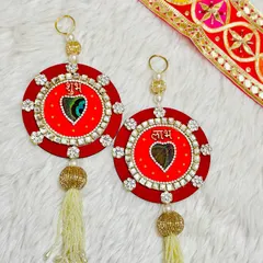 A classic red Shubh Labh hanging set, featuring a peacock feather at the heart of the design. The stone work border adds a touch of sparkle to this auspicious piece.