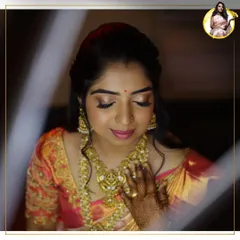 A candid moment of bridal beauty. This look features a soft, golden shimmer on the eyes and a warm pink lip, perfectly complementing the bride's intricate gold jewelry and peach-toned Kanjeevaram saree.
