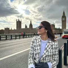 A quintessential London moment on Westminster Bridge with Big Ben in the background. I'm wearing a classic tweed coat dress with thigh-high boots, a perfect outfit for exploring the city in style during the cooler months.