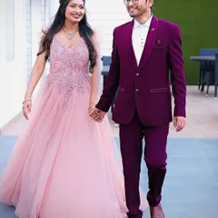 A fairytale look for your pre-wedding shoot or reception. This flowing pink net gown for her is perfectly complemented by a sharp wine-colored tuxedo for him.