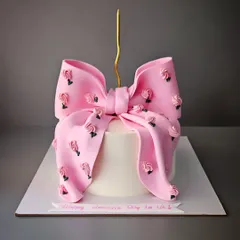 The famous bow cake, this time for Women's Day. This vanilla cake with chocolate truffle is decorated with a large pink bow adorned with tiny roses.