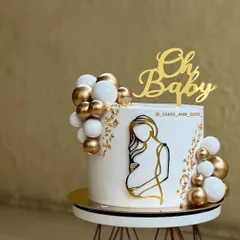 An elegant and modern baby shower cake. The design features clean, sharp edges, a gold silhouette, and delicate balloon clusters. Achieving that perfectly smooth buttercream finish is a core skill we focus on in all our hands-on cake decorating classes.