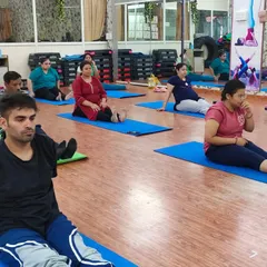 Participants in a group class practicing a seated preparatory pose. We always start with gentle movements to warm up the body and focus the mind before moving into deeper asanas.