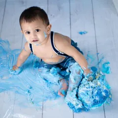 The aftermath of a successful cake smash is a work of art in itself. This overhead shot captures the beautiful mess and the happy baby sitting right in the middle of his masterpiece.