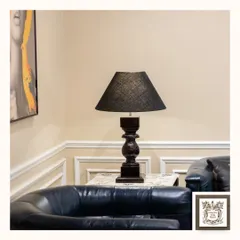 A closer look at the classic black table lamp, highlighting the texture of the lampshade and the detailed carving on its wooden base. It's a versatile piece that complements a modern classic interior.