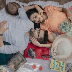 An overhead view of a cozy, retro-themed picnic. I focus on capturing these candid, joyful interactions and the little details that make your relationship special, from the vintage radio to the shared laughter.