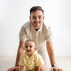 A playful father and son moment on the floor, capturing the special bond they share.