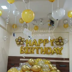 This cheerful birthday room decoration uses a gold and silver color scheme. The setup includes "Happy Birthday" foil balloons above the bed, with dozens of latex balloons floating on the ceiling and gathered on the bed.