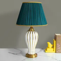 This lamp is a study in classic elegance with a modern twist. The white ceramic base with vertical gold stripes is paired with a rich, pleated teal shade, creating a sophisticated look for a desk or side table.