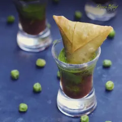 A modern take on a beloved Indian snack. These mini samosas are served in shot glasses with layers of green and tamarind chutney, offering a burst of flavor in a single, convenient bite.