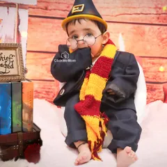 A little wizard in training. This adorable Harry Potter-themed portrait captures a shy, magical moment, complete with round glasses and a Gryffindor scarf.