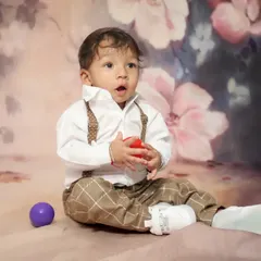 What a dapper little man! This toddler portrait captures his curious expression perfectly. The suspenders and bow tie add such a cute, classic touch.