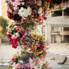 Detail of the floral spiral on the pillar of the upside down garden mandap. This shows the intricate craftsmanship involved in weaving countless flowers into a seamless, artistic structure for a luxury wedding.