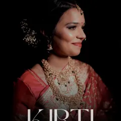 A stunning portrait of the bride, Kirti, at her reception. The dramatic lighting highlights her elegant saree, intricate jewelry, and radiant smile.