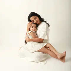 A mother's embrace is the safest place on earth. This serene portrait of a mother holding her daughter close is the epitome of comfort and love.