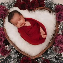 I believe every newborn is a tiny miracle. For this newborn portrait, we used a heart-shaped basket and rich, deep red tones to create a warm, love-filled setting that feels as precious as the baby sleeping inside.