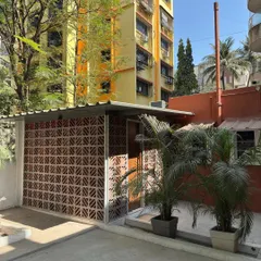 The exterior of our studio extension in Mumbai, featuring a terracotta brick jali screen. This design choice filters the harsh sun while creating a beautiful play of light and shadow, showcasing our belief in using indigenous, locally sourced materials to create modern, climate-responsive architecture.