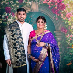 A proud moment for the parents-to-be, captured during their traditional Indian maternity session. The rich colors of the saree and the classic studio backdrop create a timeless portrait.