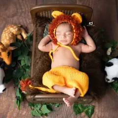Here is our little Simba, dressed in a hand-knitted lion costume and sleeping soundly on a tiny bed in the jungle.