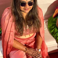 A candid shot of a client admiring her fresh henna design during a celebration.