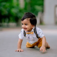 A candid shot of a baby crawling with a huge, happy grin. This photo perfectly captures the joy and energy of a little one exploring their world.