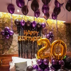 For this 20th birthday, I decorated a room with a moody and stylish purple and black theme. The setup includes balloons on the ceiling, large foil numbers for the age, and a tinsel backdrop, transforming a personal space into a party zone.