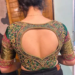 A perfect example of how a blouse can be a statement piece. This emerald green bridal blouse features a dramatic heart-shaped cutout, framed with dense zardosi and resham embroidery. The sleeves are equally detailed, making it stunning from every angle.
